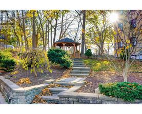 A gazebo is surrounded by trees and plants in a park.