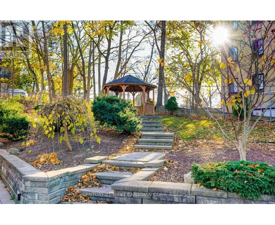 A gazebo is surrounded by trees and plants in a park.