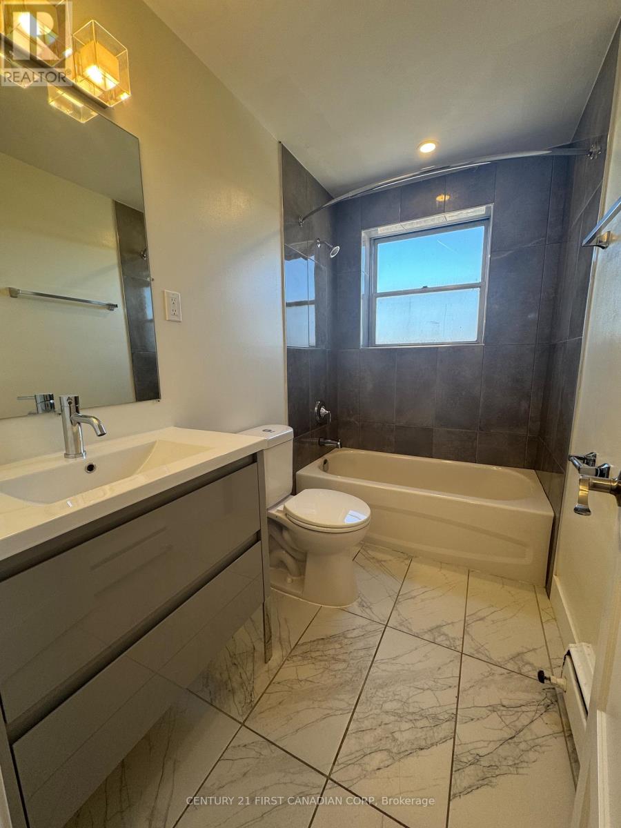 A bathroom with a toilet, sink, and bathtub.
