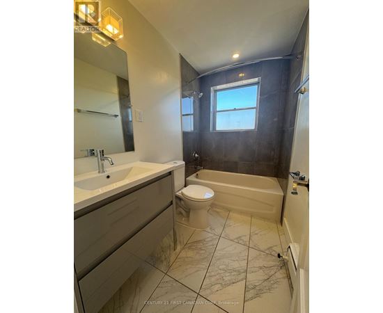 A bathroom with a toilet, sink, and bathtub.