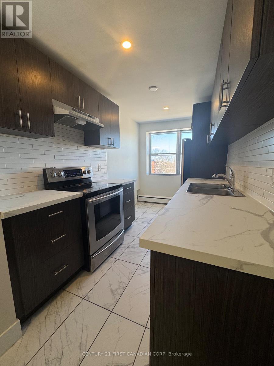 A kitchen with dark wood cabinets and white countertops.