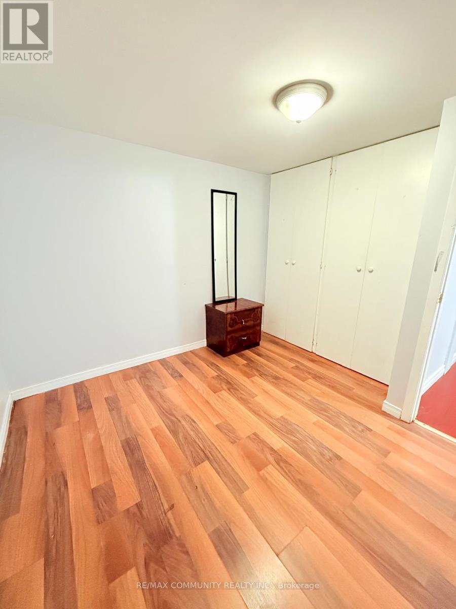 A room with wooden flooring and white walls.