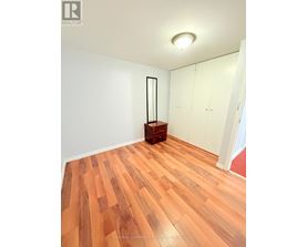 A room with wooden flooring and white walls.