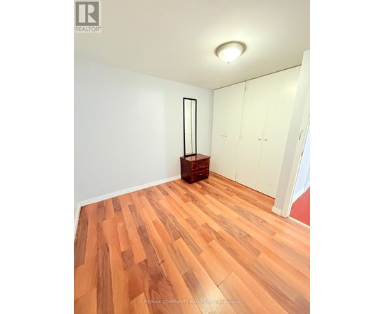 A room with wooden flooring and white walls.