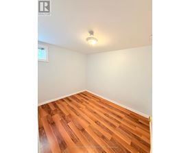 A room with wooden flooring and a window.