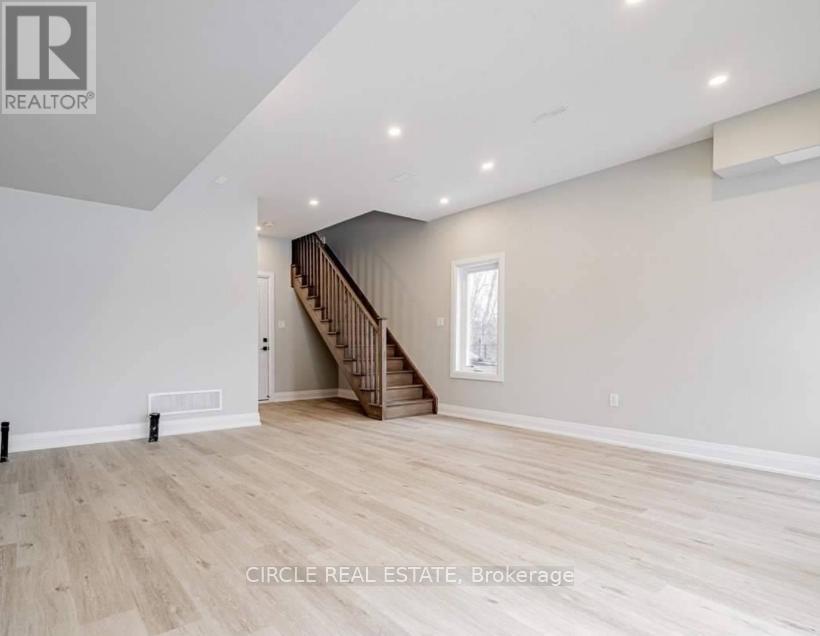 A spacious room with a staircase and a window.