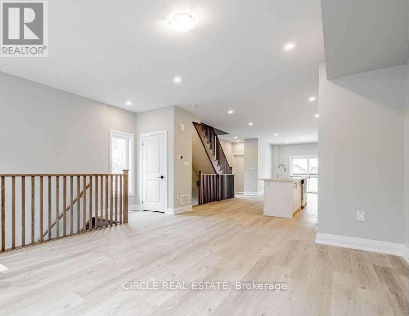 A spacious living room with a staircase leading to the upper floor.