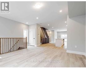 A spacious living room with a staircase leading to the upper floor.