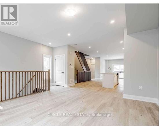 A spacious living room with a staircase leading to the upper floor.