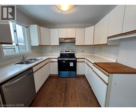 A kitchen with white cabinets and a wooden counter top.