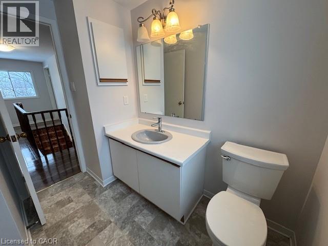A bathroom with a toilet, sink, and mirror.