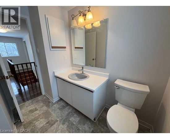 A bathroom with a toilet, sink, and mirror.