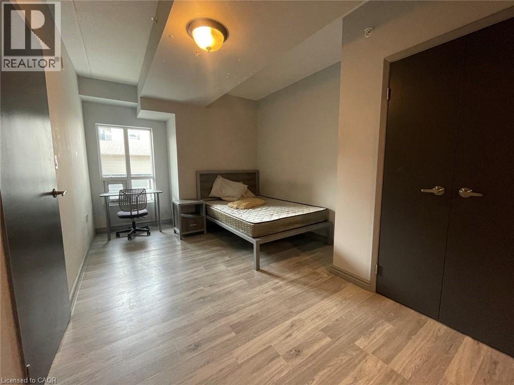 A bedroom with a bed, desk, and chair.