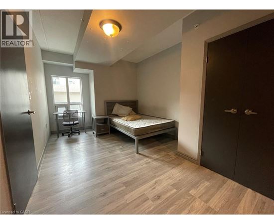 A bedroom with a bed, desk, and chair.