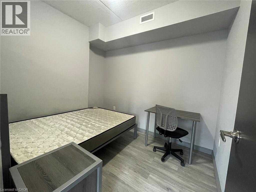 A bedroom with a bed, desk, and chair.