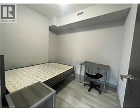 A bedroom with a bed, desk, and chair.