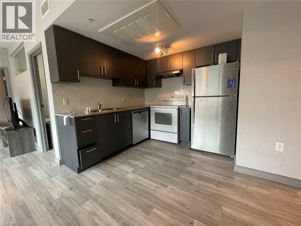 A modern kitchen with dark wood cabinets and stainless steel appliances.