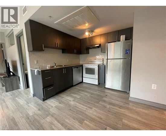 A modern kitchen with dark wood cabinets and stainless steel appliances.