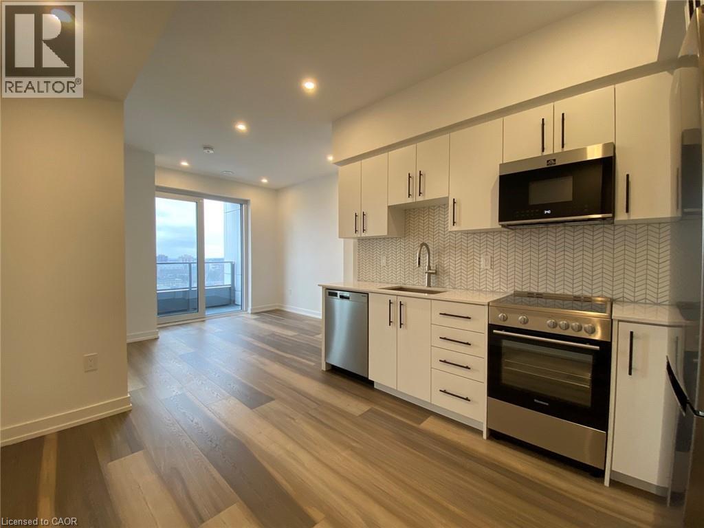 A modern kitchen with white cabinets and stainless steel appliances.