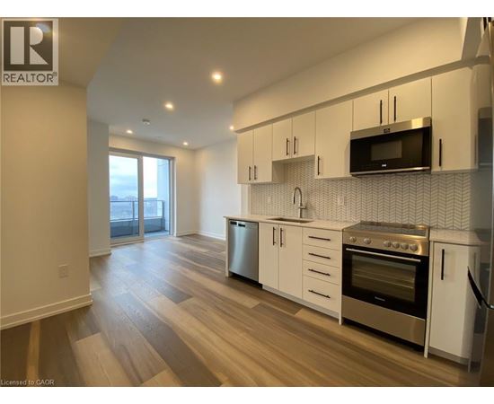 A modern kitchen with white cabinets and stainless steel appliances.