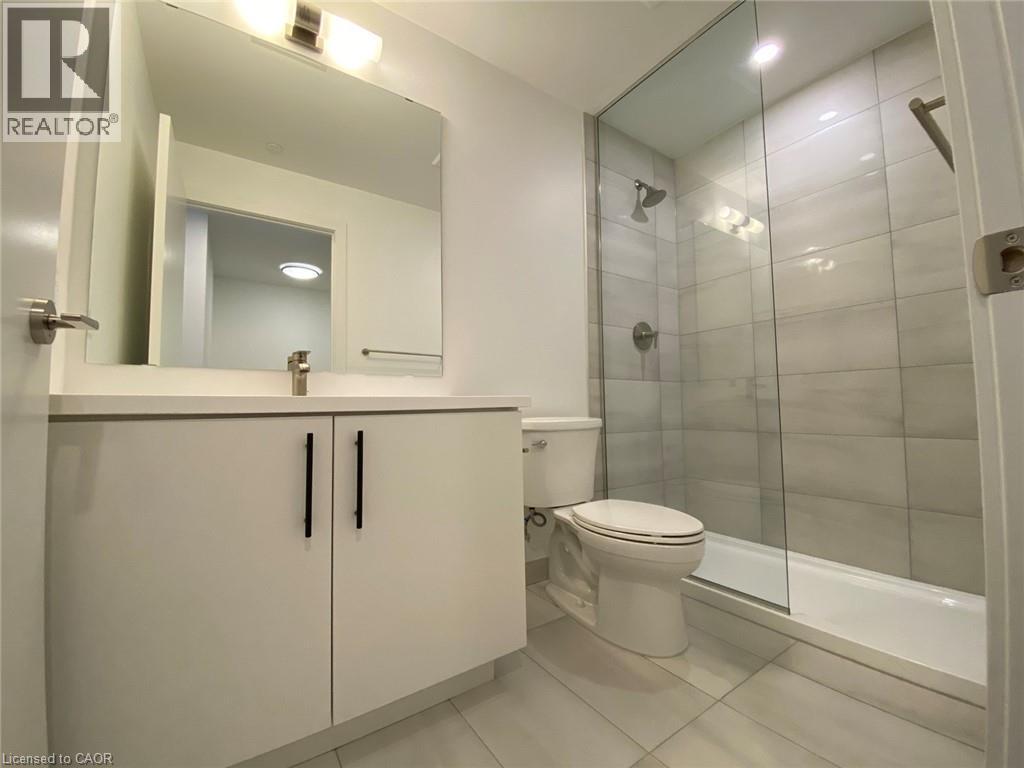 A bathroom with a toilet, sink, and mirror.
