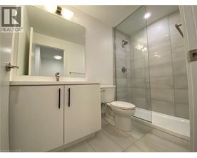 A bathroom with a toilet, sink, and mirror.