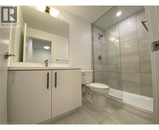 A bathroom with a toilet, sink, and mirror.
