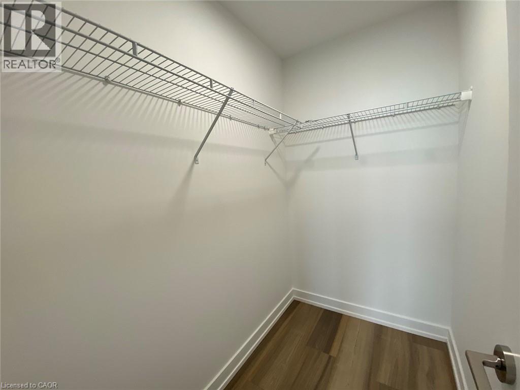 A white wall with a metal rack and a wooden floor.