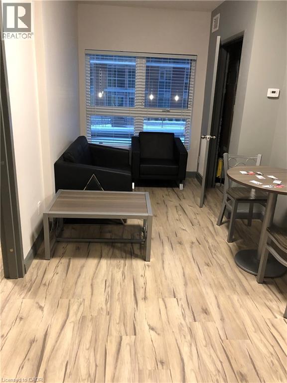 A living room with a black couch, a grey coffee table, and a wooden floor.