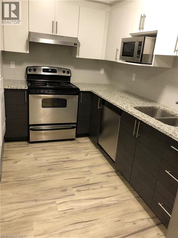 A kitchen with a stove, oven, and microwave.
