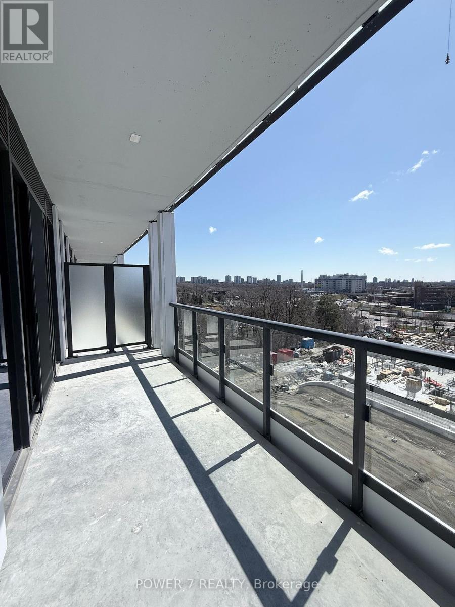 A balcony with a view of a construction site and buildings in the distance.