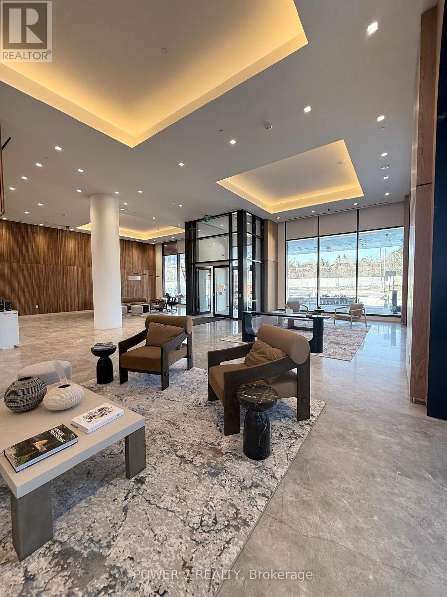 A spacious lobby with a marble floor and a large window overlooking a parking lot.