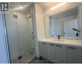 A bathroom with a sink, mirror, and shower.