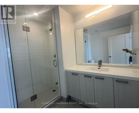 A bathroom with a sink, mirror, and shower.
