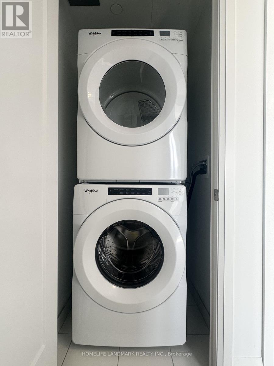 Two white Whirlpool washing machines in a small laundry room.