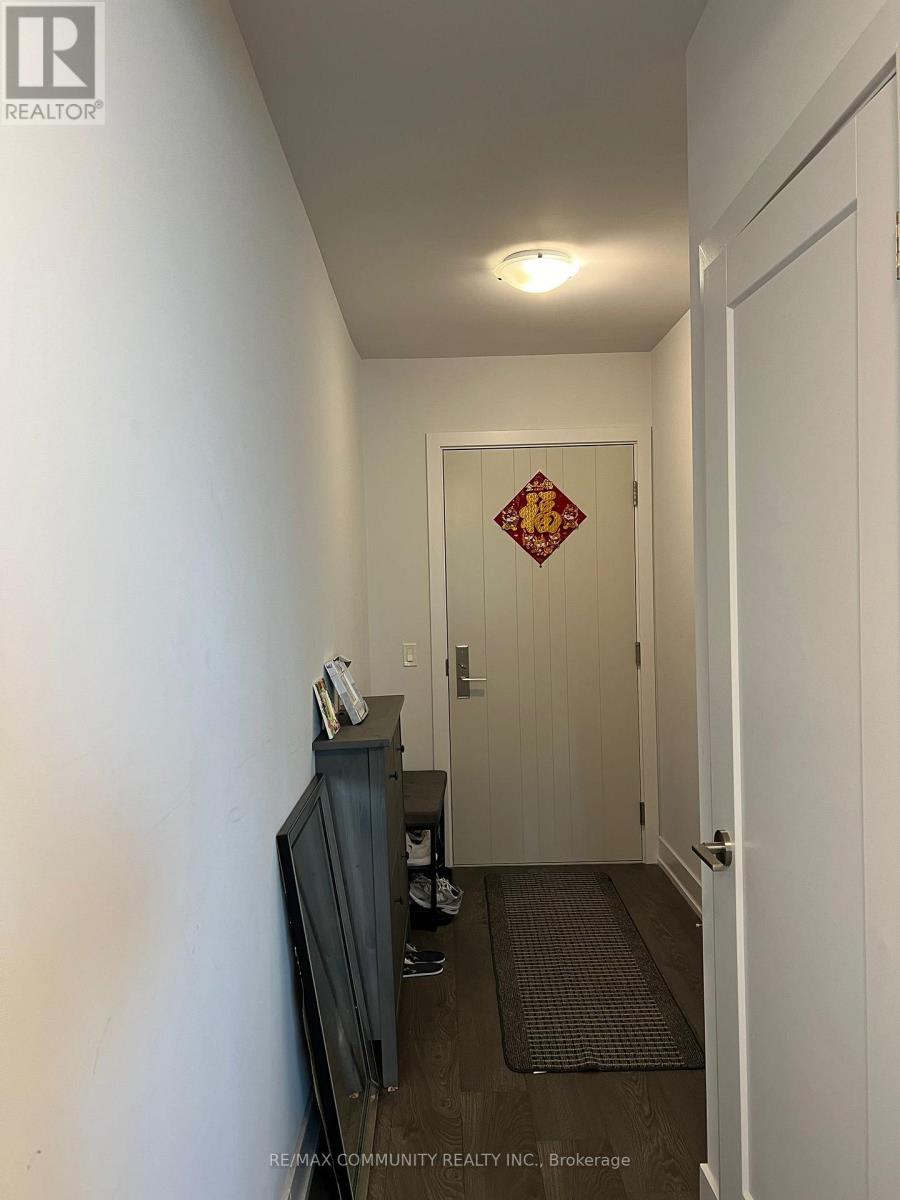A hallway with a door and a wall-mounted television.