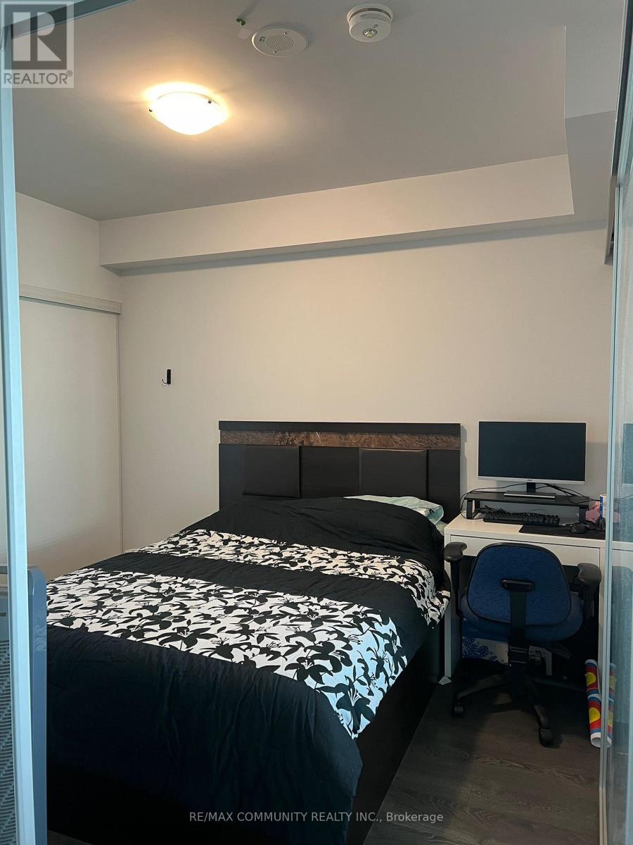 A bedroom with a bed, desk, and chair.