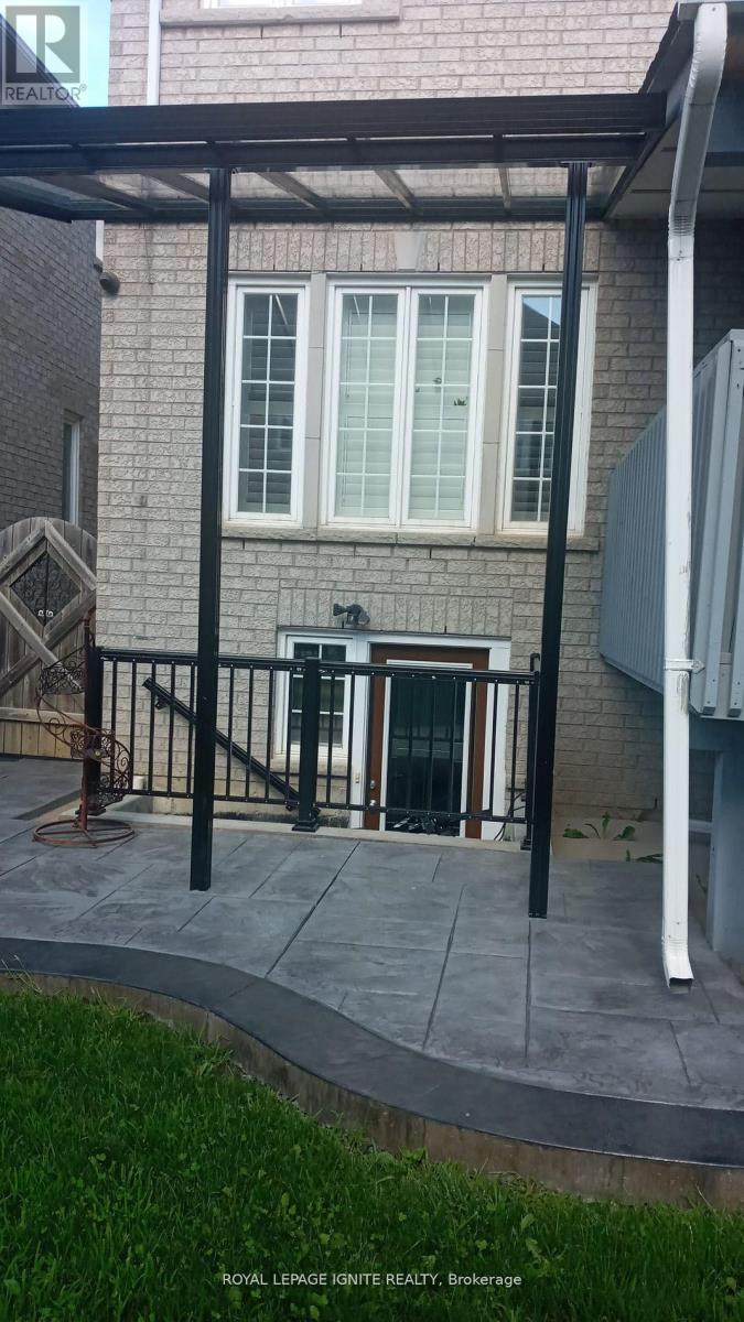 A patio area with a black railing and a white pillar.
