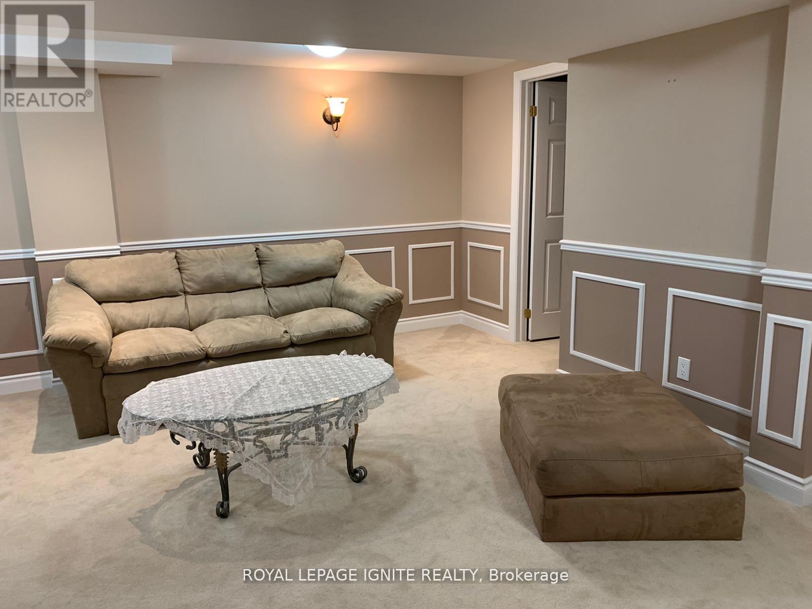 A living room with a beige couch and a round table with wheels.