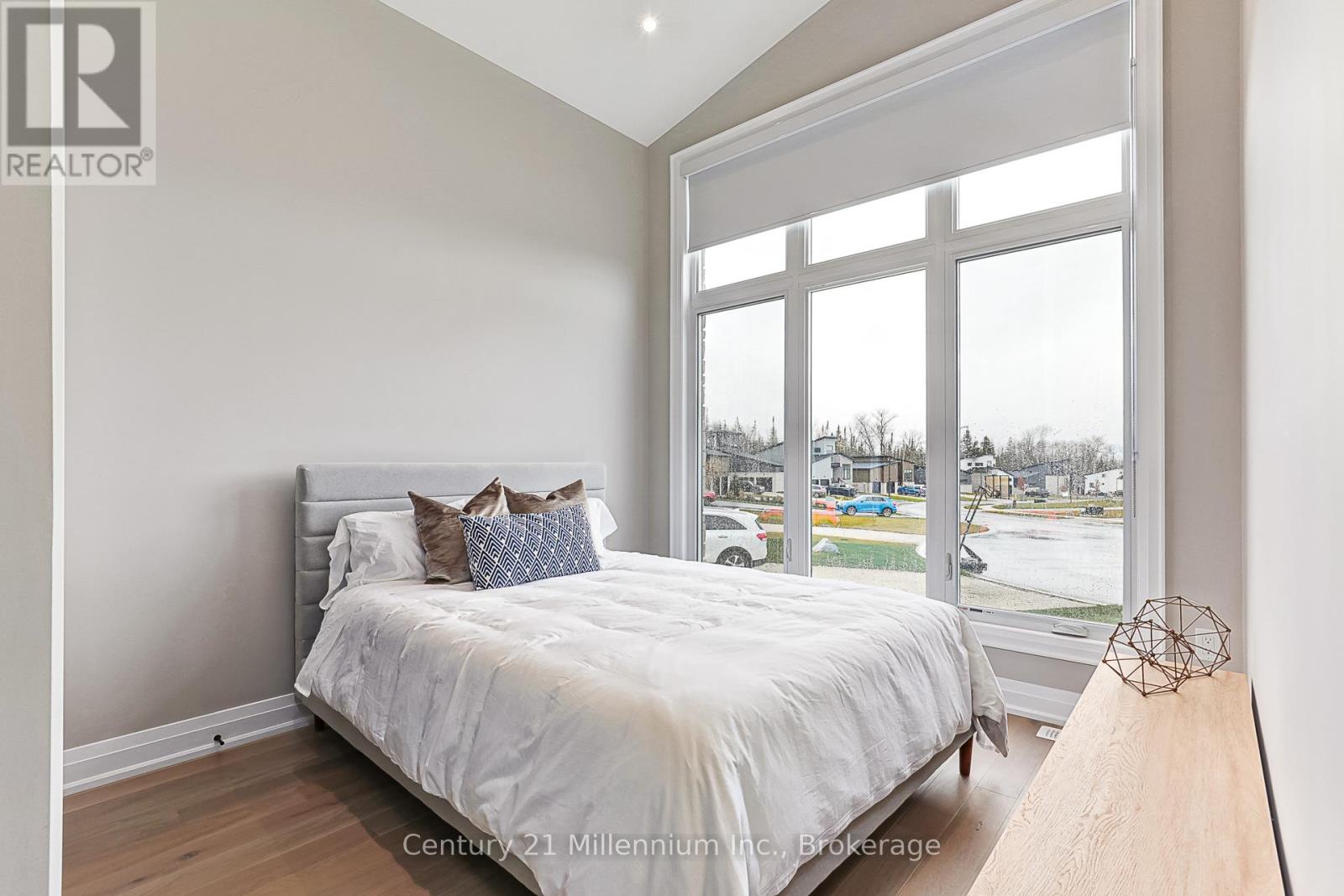 A bedroom with a large bed and a view of the street outside.