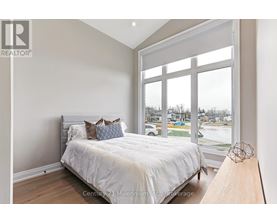 A bedroom with a large bed and a view of the street outside.