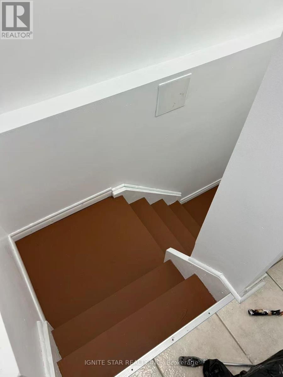 A staircase with brown tiles and white walls.