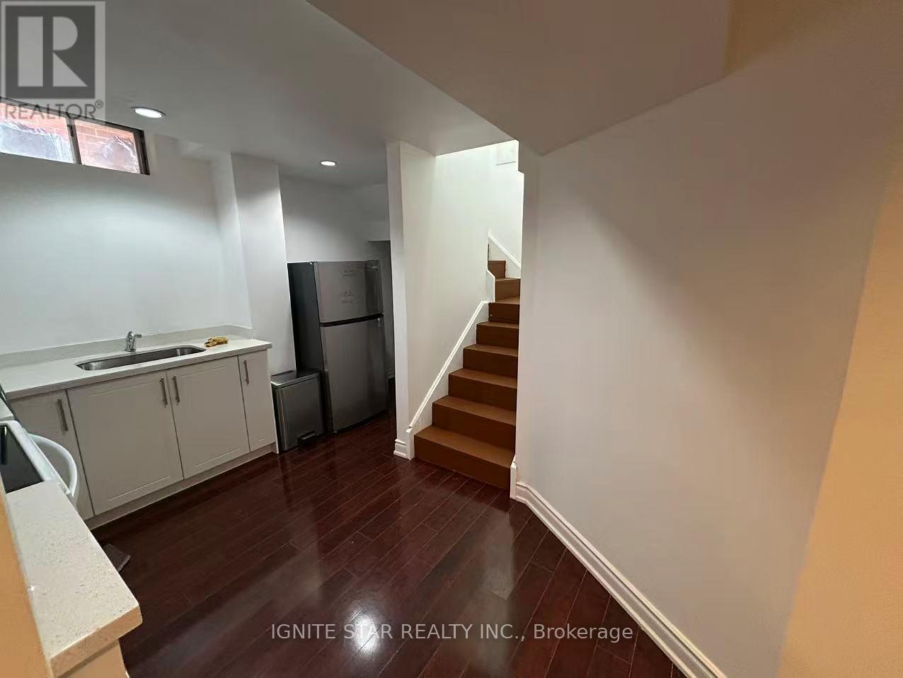 A kitchen with white cabinets and a stainless steel refrigerator.