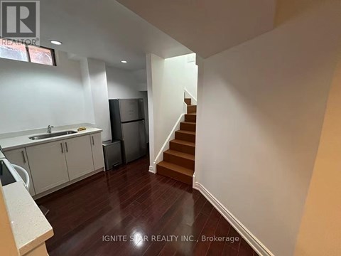 A kitchen with white cabinets and a stainless steel refrigerator.