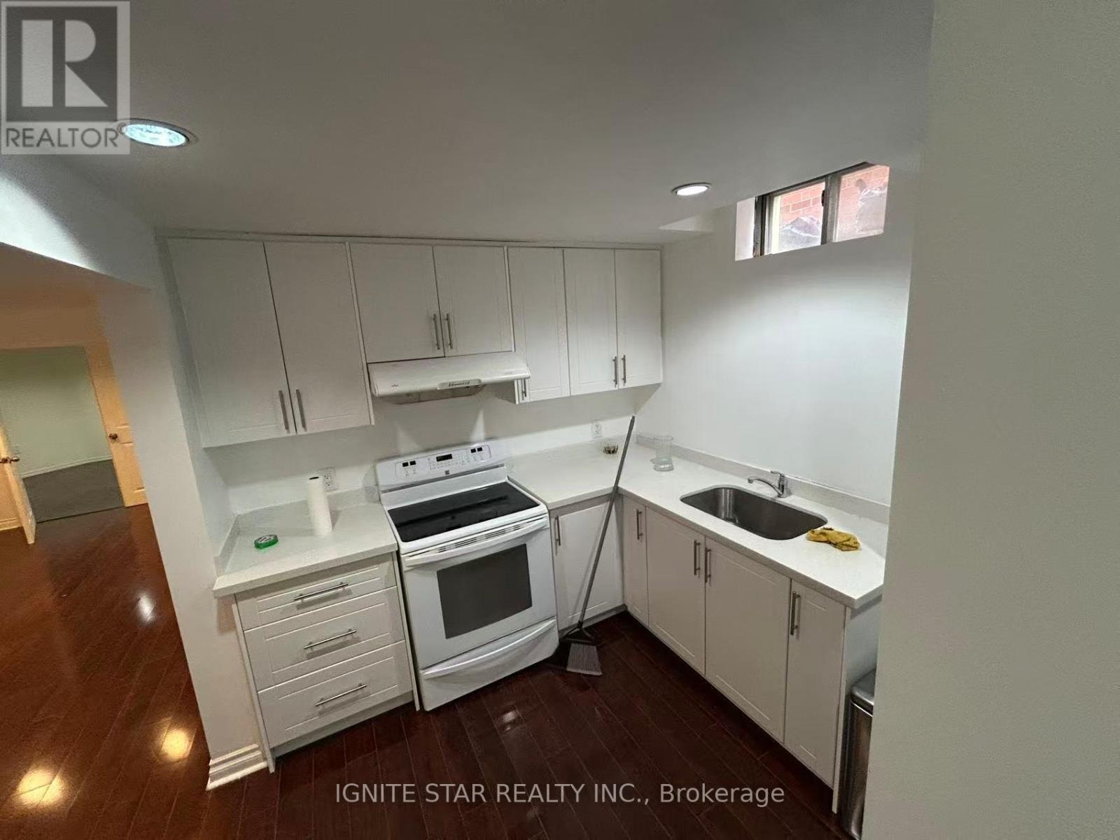 A kitchen with white cabinets and appliances is shown.