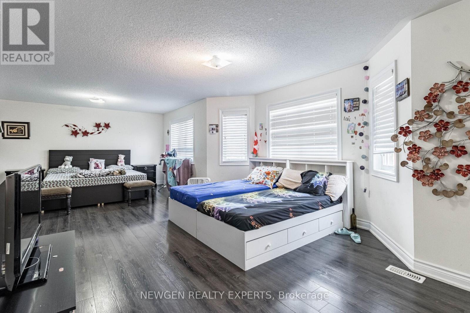 A bedroom with two beds and a TV.