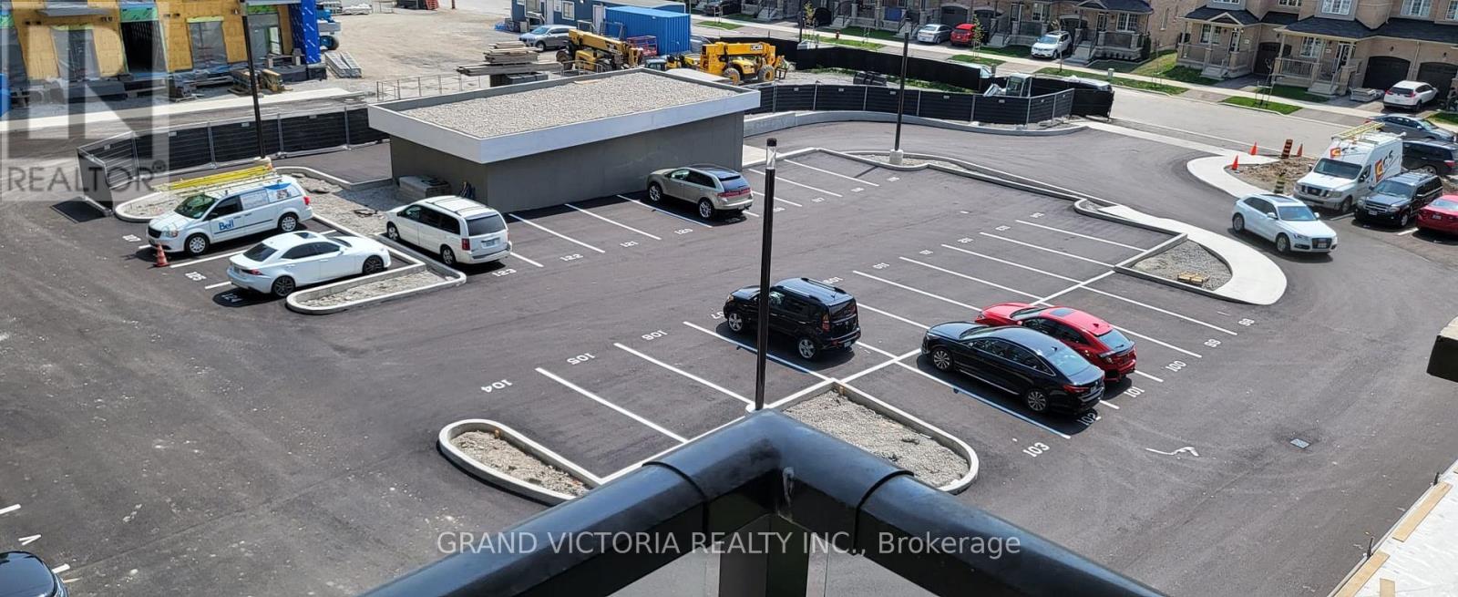 A parking lot with cars and a building in the background.