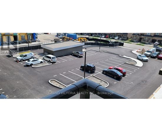 A parking lot with cars and a building in the background.