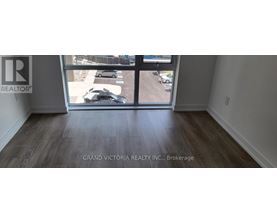 A room with a view of a parking lot through a glass door.