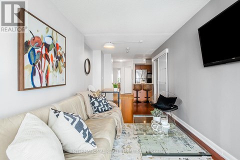 A living room with a couch, a coffee table, and a painting on the wall.
